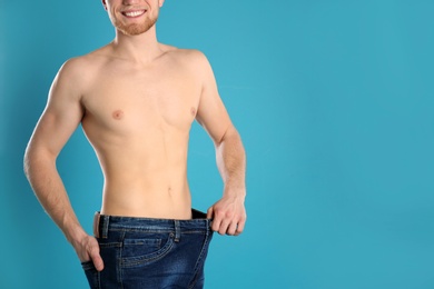 Young man in oversized jeans on color background, closeup. Space for text