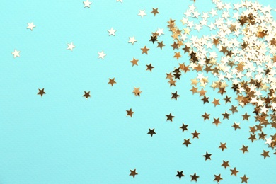 Confetti stars on light blue background, flat lay. Christmas celebration