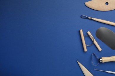 Set of clay modeling tools on blue background, flat lay. Space for text