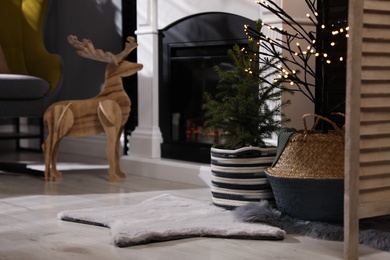 Beautiful room interior with potted fir tree and fireplace