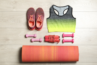Set of fitness equipment and accessories on wooden background, flat lay