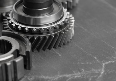 Photo of Different stainless steel gears on grey background, closeup. Space for text