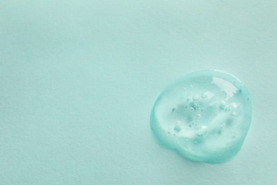 Photo of Sample of face gel on light blue background, top view. Space for text