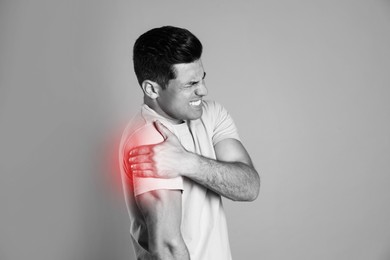 Man suffering from shoulder pain. Black and white photo 