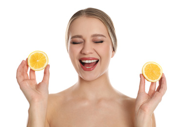 Photo of Emotional young woman with cut lemon on white background. Vitamin rich food