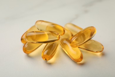 Dietary supplement capsules on white table, closeup