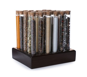Glass tubes with different spices in rack on white background