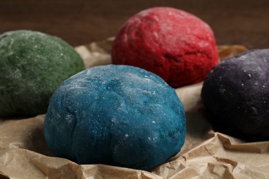 Photo of Dough painted with food colorings on table, closeup