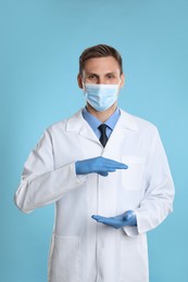 Dentist holding something on light blue background