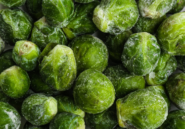 Frozen Brussels sprouts as background, top view. Vegetable preservation