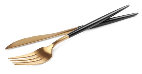 New golden fork and knife with black handles on white background