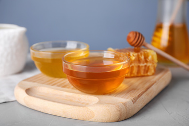 Tasty organic honey on light grey table