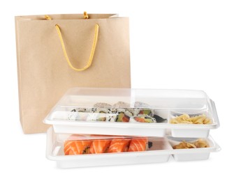 Photo of Food delivery. Plastic boxes with delicious sushi rolls near paper package on white background