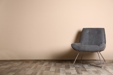 Stylish chair near color wall, space for text. Interior design