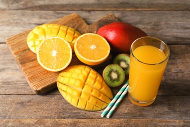 Tasty tropical drink with mango and fresh fruits on wooden table