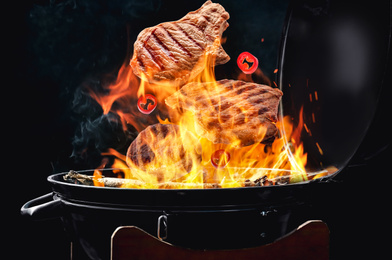 Image of Meat and chili pepper slices falling onto barbecue grill with flame against black background, closeup