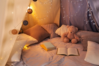 Play tent with books, pillows and Teddy bear. Modern children's room interior