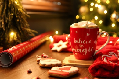 Tasty hot drink in cup with inscription Believe in Magic, space for text. Christmas atmosphere