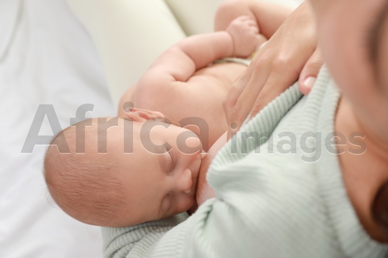 Young woman breastfeeding her little baby, above view