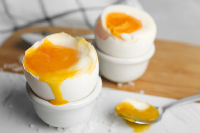 Soft boiled chicken eggs on white table, closeup