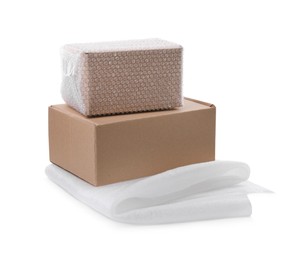 Cardboard boxes with bubble wrap and packaging foam on white background