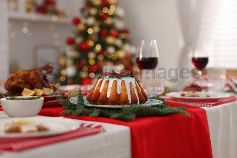 Photo of Festive dinner with delicious cake served on table indoors. Christmas Eve celebration