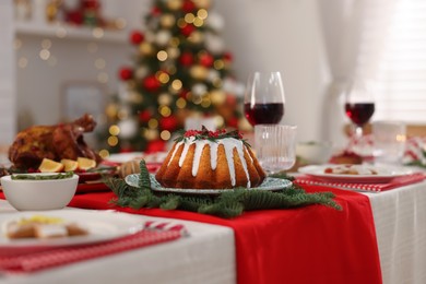 Festive dinner with delicious cake served on table indoors. Christmas Eve celebration