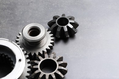 Photo of Different stainless steel gears on grey background. Space for text