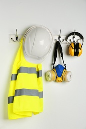 Different safety equipment hanging on white wall