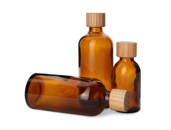 Photo of New empty glass bottles with wooden caps isolated on white