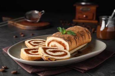Tasty cake roll with jam and mint on grey table