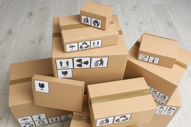 Cardboard boxes with different packaging symbols on floor, above view. Parcel delivery