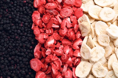 Photo of Closeup of freeze dried blueberries, strawberries and bananas as background, top view