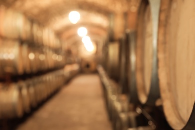 Blurred view of wine cellar with large wooden barrels