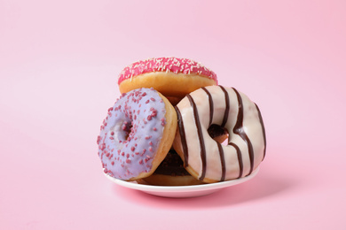 Tasty glazed donuts on pink background. Dessert food