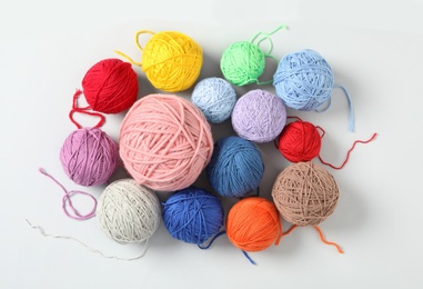 Soft colorful woolen yarns on white background, top view