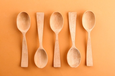 Flat lay composition with clean wooden spoons on color background