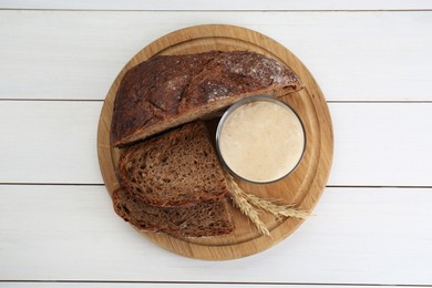 Photo of Freshly baked bread, sourdough and spikes on white wooden table, top view