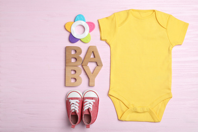 Flat lay composition with child's clothes on pink wooden table