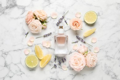 Flat lay composition with bottle of perfume and fresh citrus fruits on white marble table