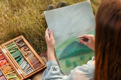 Woman drawing landscape with soft pastels outdoors, closeup