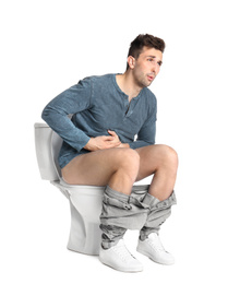 Man suffering from stomach ache on toilet bowl, white background