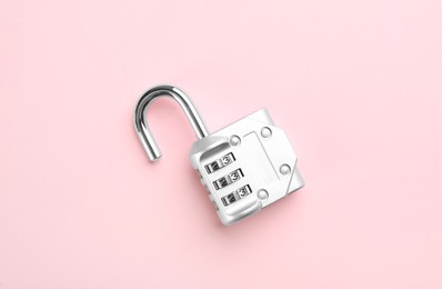 Modern combination lock on pink background, top view