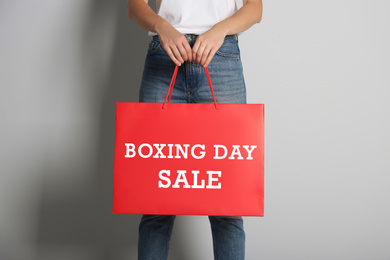 Woman holding red shopping bag with text Boxing Day Sale, closeup