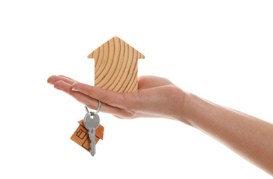 Real estate agent holding house figure and key on white background, closeup