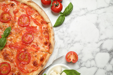 Photo of Delicious pizza Margherita and ingredients on white marble table, flat lay. Space for text