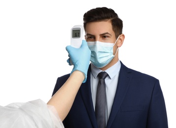 Doctor measuring man's temperature on white background, closeup. Prevent spreading of Covid-19