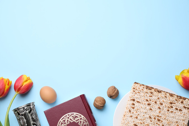 Flat lay composition with symbolic Pesach (Passover Seder) items on light blue background, space for text