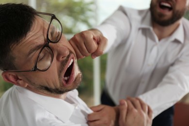 Photo of Emotional colleagues fighting in office, closeup. Workplace conflict