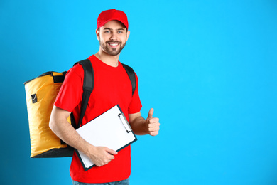 Courier with thermo bag and clipboard on light blue background, space for text. Food delivery service